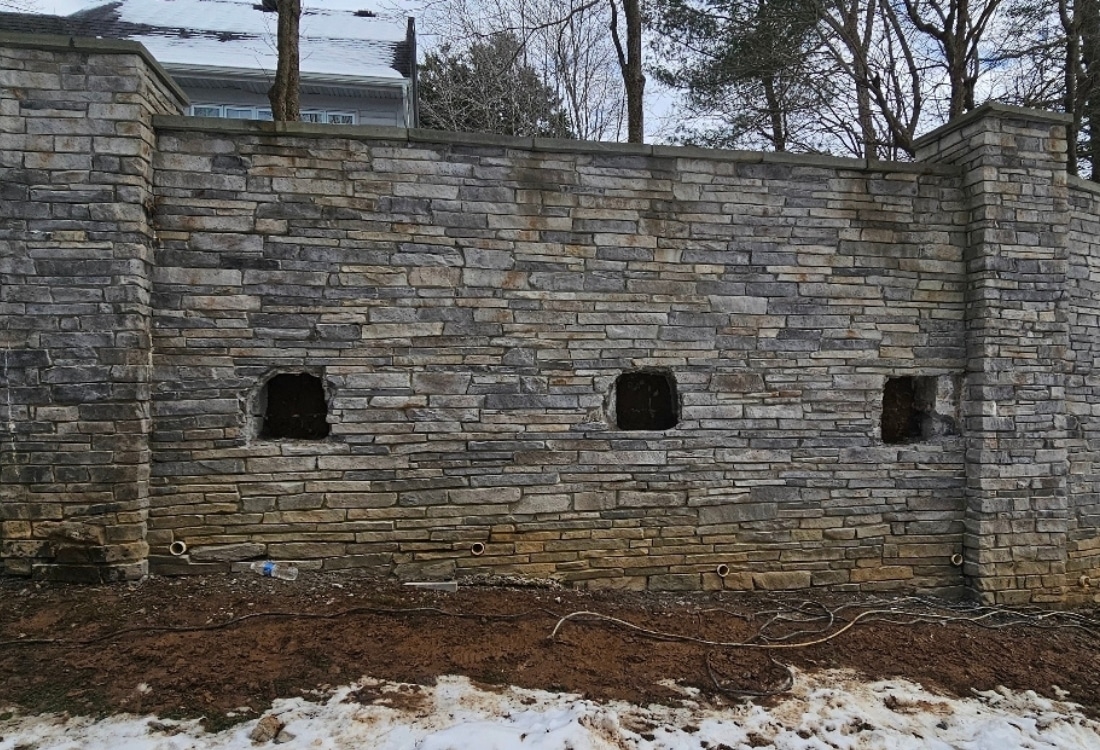 Unstable retaining wall before repair showing visible cracks and signs of structural stress before repair.
