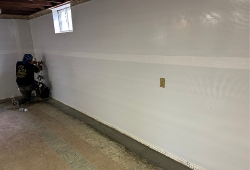 LUX team installing vapor barrier for expert basement waterproofing services in Northern Virginia, protecting homes from water damage.
