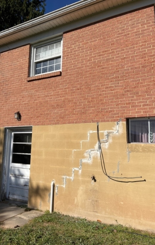 Multiple cracks in a foundation wall, showing common causes of foundation damage in Winchester, VA, that need repair.