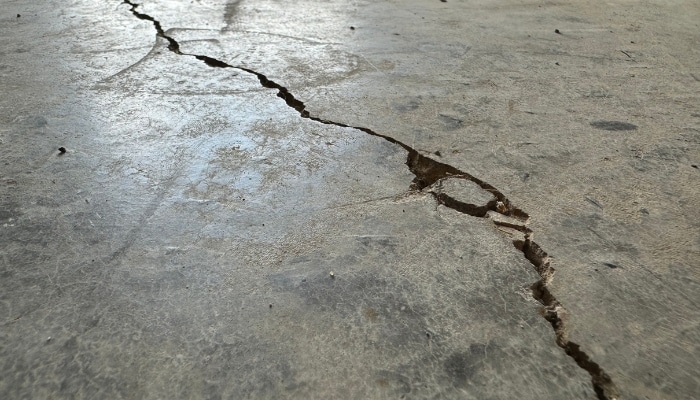 Cracks in the basement floor in Burke, VA, signaling foundation or water damage, need expert foundation repair services.