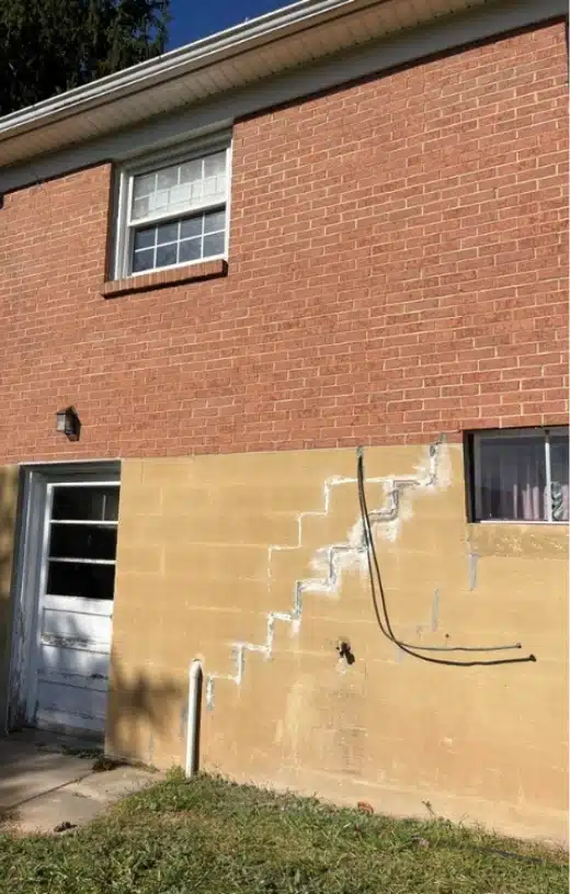 Foundation with severe cracks due to soil movement, moisture, or poor construction, a common cause of foundation damage in Burke, VA.