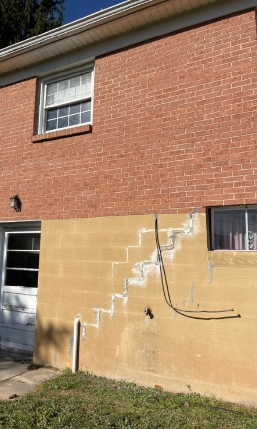 Foundation wall with stair-step cracks, showing causes of foundation damage in Front Royal, VA, due to shifting and settlement issues.