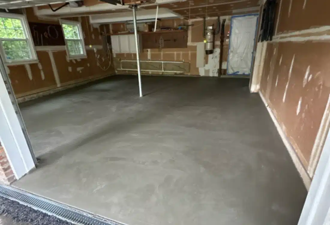 Reinforced and level garage concrete floor after full slab replacement in Winchester, VA, with drainage and moisture barrier.