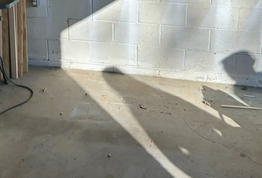 Cracked garage floor and walls before foundation repair in Reston, VA, showing signs of foundation settling and shifting.