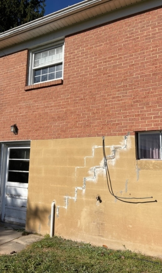 Foundation wall with multiple cracks showing the causes of foundation issues in Harpers Ferry, WV, that need expert repair solutions.