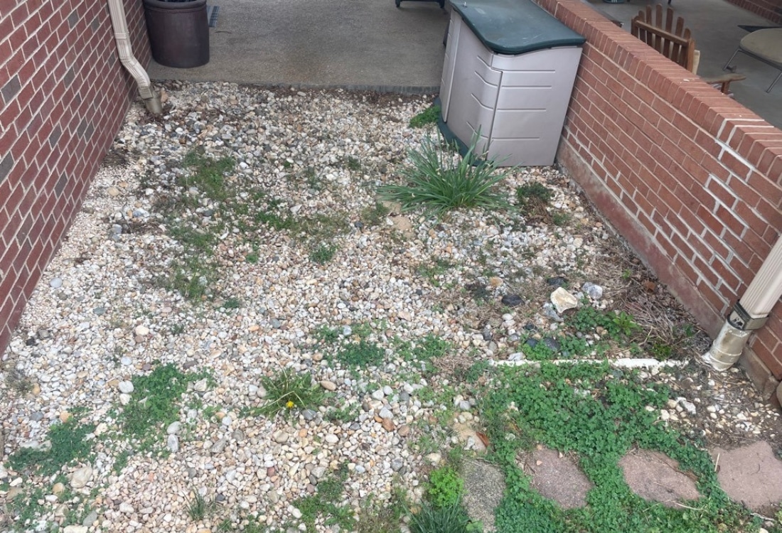 Messy, uneven gravel walkway outside home before concrete walkway installation in Staunton, VA.