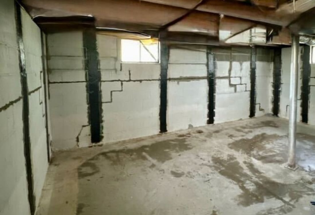 Stabilized basement wall showing reinforced straps preventing further movement after carbon fiber repair