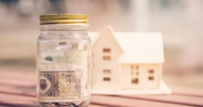 Savings jar with money bills in front of house model symbolizing cost savings, an advantage of foundation repair in Martinsburg, WV.