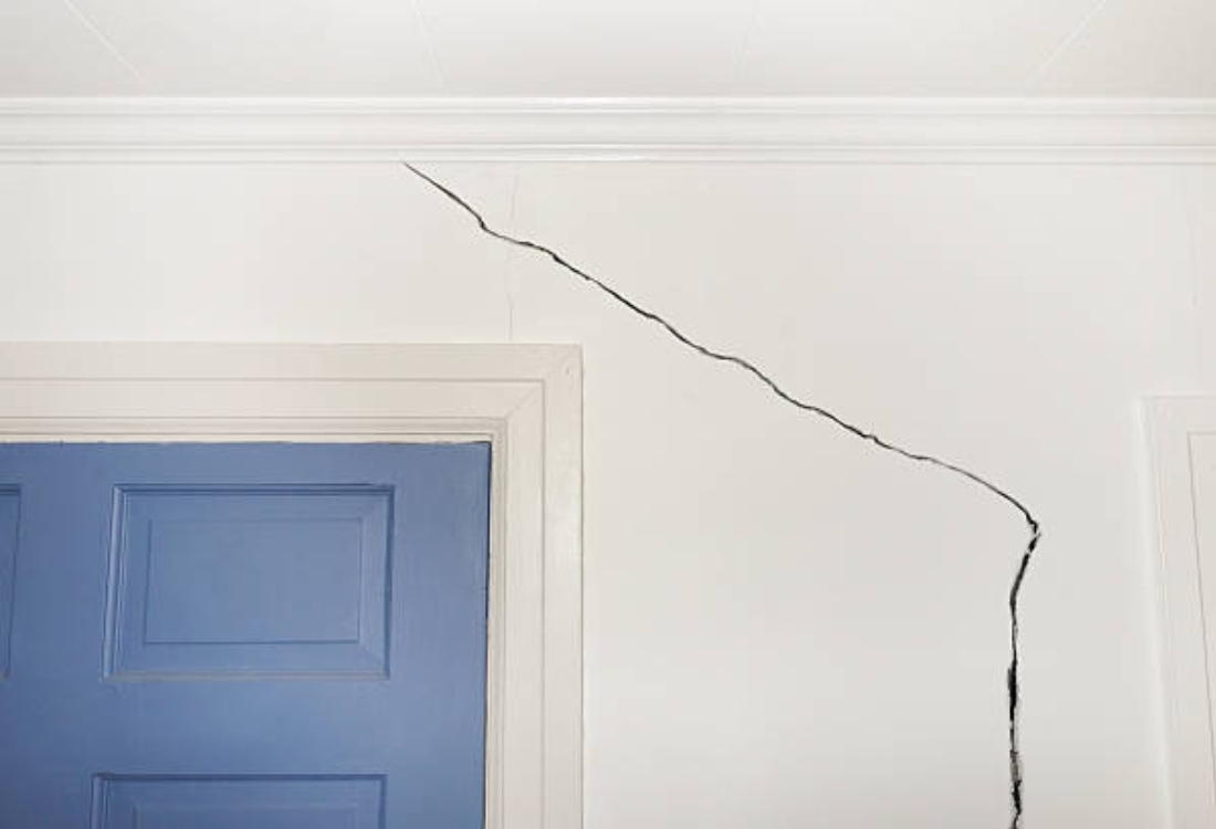 Interior wall crack near door frame showing early signs of foundation problems, needing home foundation repair in Fairfax, VA.