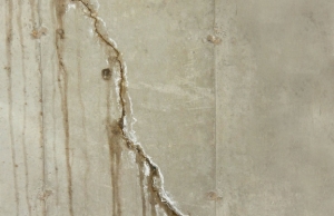 Crack in a concrete basement wall with water leakage in Berryville, VA, a sign of basement flooding.