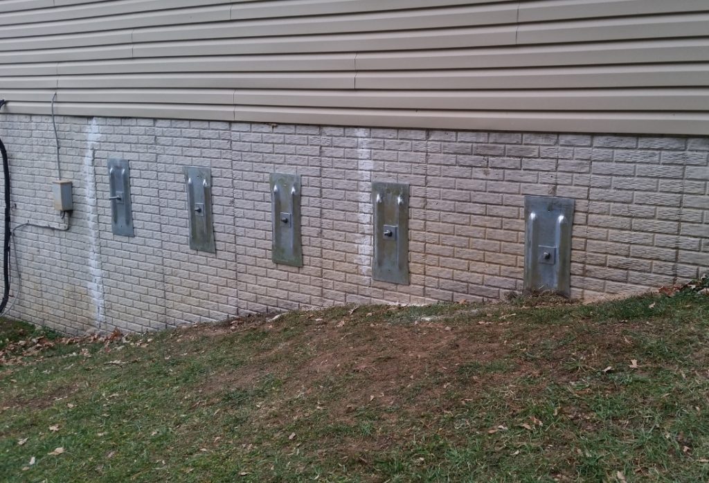 Basement wall reinforced with steel wall anchors to prevent bowing, a home foundation repair in Staunton, VA.