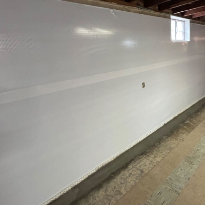Installed interior basement waterproofing with a wall vapor barrier, a basement flooding solution in Southbridge, VA.
