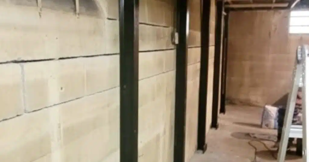 Steel I-beams installed inside the basement wall to stabilize and straighten bowing foundation walls in Berkeley, WV.