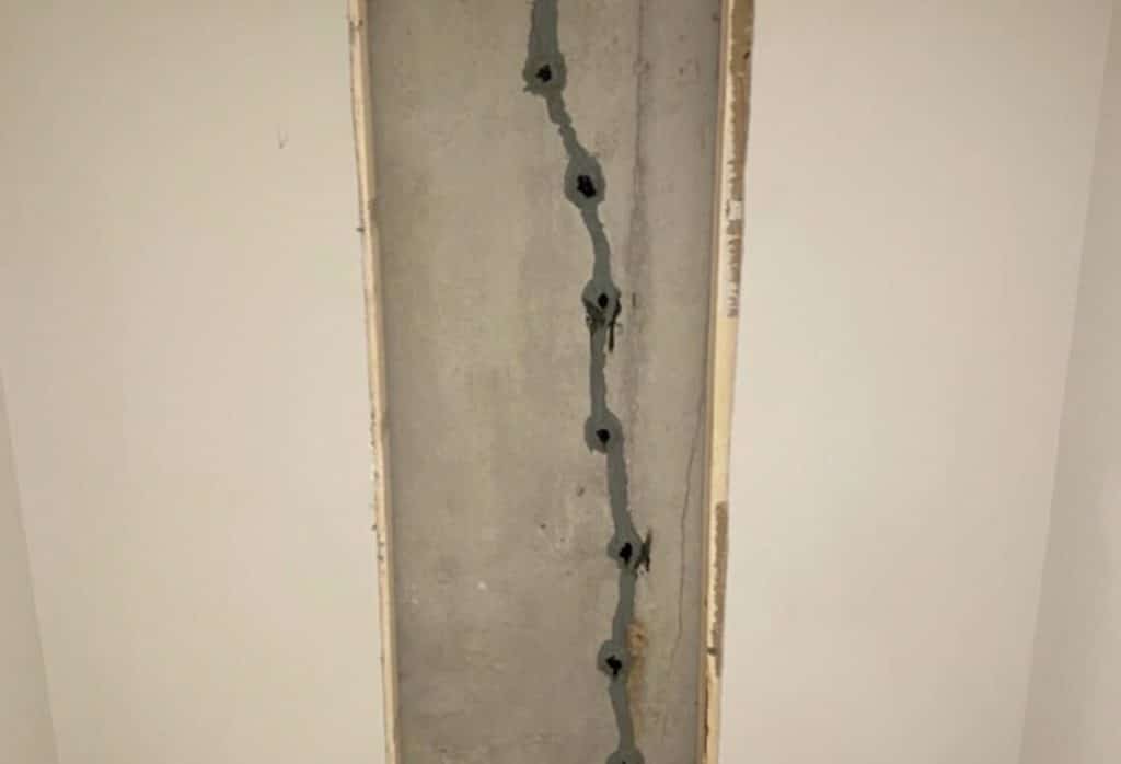 Close-up of epoxy injection sealing a basement wall crack, a basement waterproofing method to stop water seepage in Fairfax, VA.