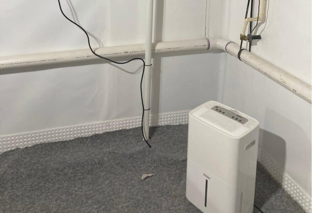 A dehumidifier running in a basement to lower humidity as part of a basement waterproofing method in Berryville, VA.