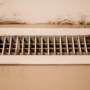 Dirty basement vent showing inadequate ventilation in Front Royal, VA, which traps humidity and causes paint bubbling over time.