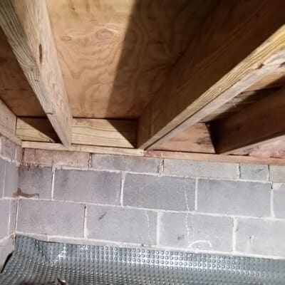 New lumber sistered alongside damaged joists to reinforce weakened support, a crawl space wood rotting solution in Reston, VA.
