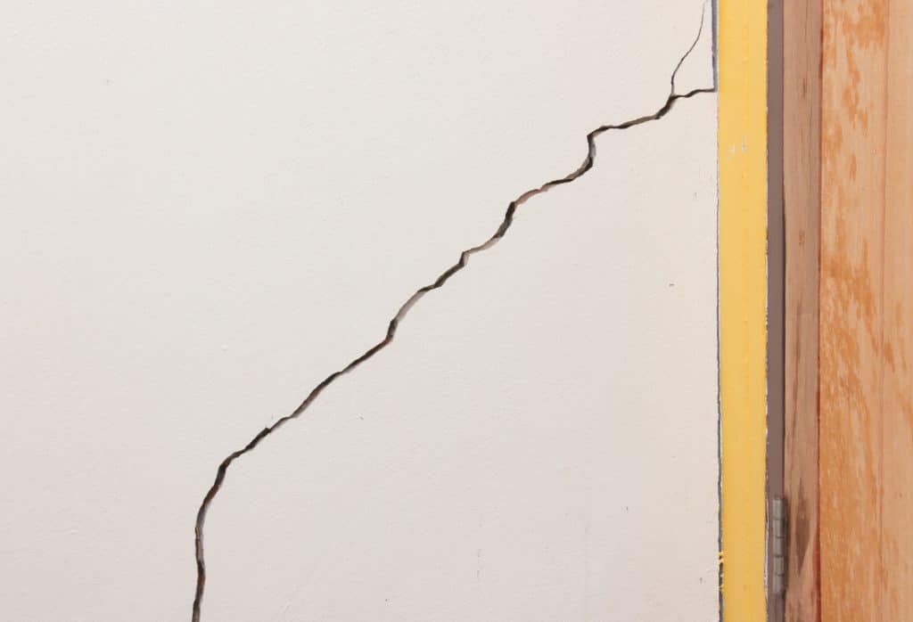 Interior wall cracks with visible stress lines indicating foundation movement, and a sign foundation is sinking in White Post, VA.