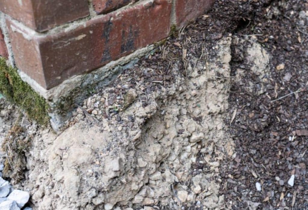 Soil erosion and ground movement near a home’s foundation, common causes that can lead to foundation sinking in Alexandria, VA.
