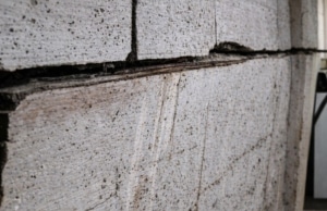 Foundation wall bowing inward with horizontal crack and structural displacement, signs of a sinking foundation in Fairfax, VA.