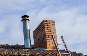 Brick chimney leaning and tilting away from the roofline, indicating foundation settlement and sinking foundation in Alexandria, VA.