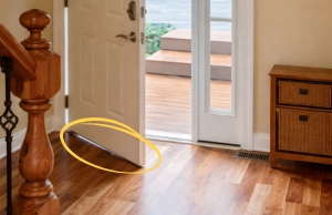 Basement entry door uneven at the bottom near the threshold, a sign of a sinking concrete slab in Fairfax, VA.
