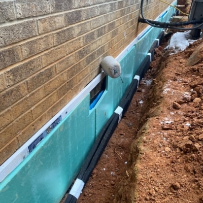 Exterior waterproofing membrane and drainage system installed along foundation wall, a sinking foundation solution in Reston, VA.