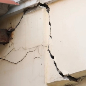 Deep stair-step cracks splitting exterior corner wall from natural ground movement causing drywall cracks in Ashburn, VA..