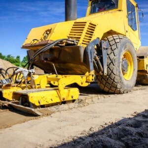 Yellow soil compactor machine compacting ground to prevent poor soil compaction, causing an uneven basement floor in Berryville, VA.