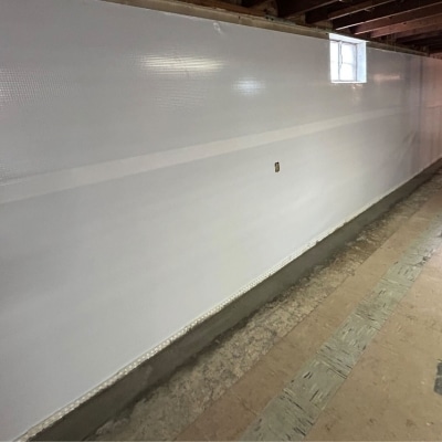 An installed heavy-duty plastic vapor barrier on the interior basement walls to block moisture from seeping.
