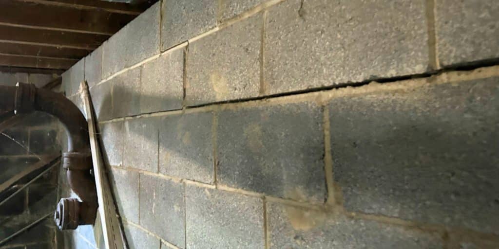 A bowing basement wall showing inward movement and horizontal cracks that require proven basement wall repair ni Northern, VA.