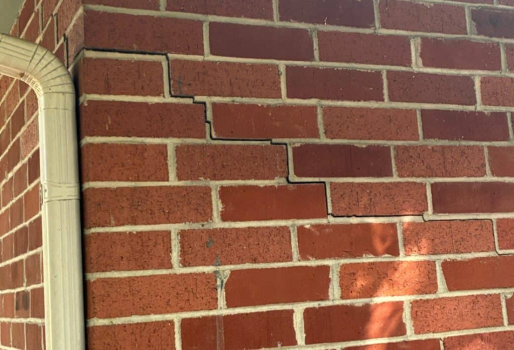 Stair step crack in brick wall showing structural damage that can affect foundation repair cost in Northern Virginia.