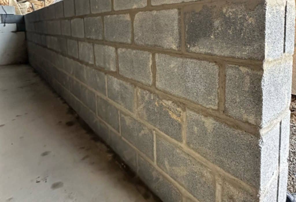 Rebuilt concrete block bowed basement wall in Charles Town, WV after foundation wall replacement to restore structural integrity.