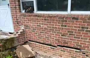 Horizontal crack running down a poured concrete foundation wall surface, a sign of a bowing foundation wall in Clear Brook, VA.