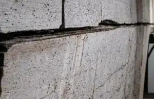 Close-up of bowing concrete block basement wall showing block separation, a sign of bowing basement wall in Alexandria, VA