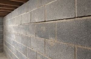 Concrete block foundation wall leaning inward with mortar joint separation, a sign of a bowing foundation wall in Bristow, VA.