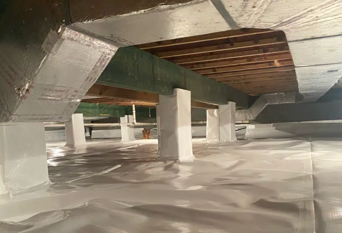 Sealed white vapor barrier, wrapped columns, andradiant barrier insulation on walls after crawl space encapsulation, Luray, VA.