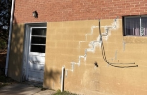 Stair-step crack running diagonally through exterior brick mortar joints, a sign of bowing foundation wall in Stephens City, VA.