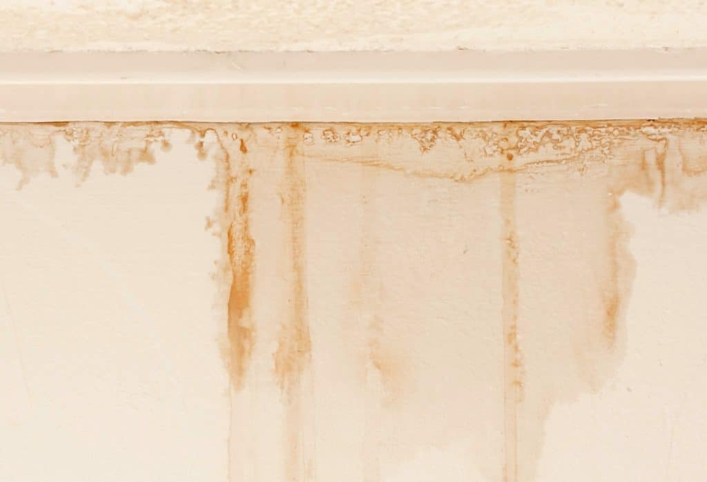 Brown rust water stains streaking down a basement wall, a finding in the basement inspection checklist in Alexandria, VA.