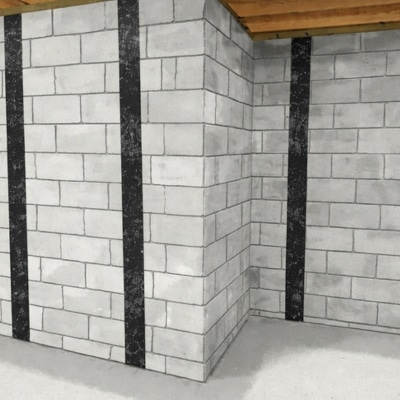 Carbon fiber reinforcement straps bonded vertically to fix concrete block cracks in basement wall in Charles Town, WV.