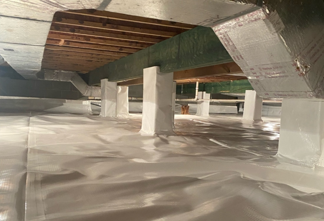 Encapsulated crawl space with white vapor liner on the floor and wrapped columns eliminating crawl space odor in Winchester, VA.