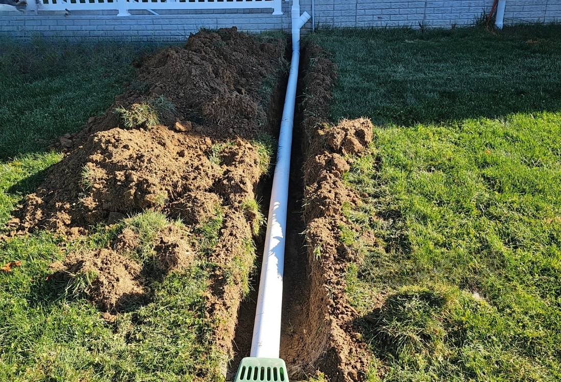 Downspout extension installed to direct roof runoff away and prevent standing water around the house in Winchester, VA.