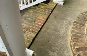 Gap between concrete porch slab and exterior wall showing sinking porch separation in Brambleton VA home.