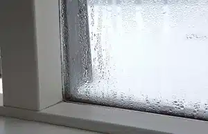 Heavy condensation covering basement window from high indoor humidity, sign of musty smell in basement in Brambleton, VA.