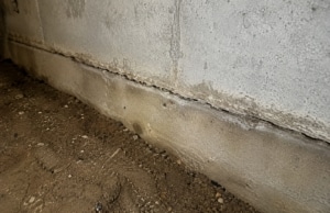 Crack at the base where foundation wall meets the footing, sign of crack in crawl space foundation wall problem in Linden, VA.