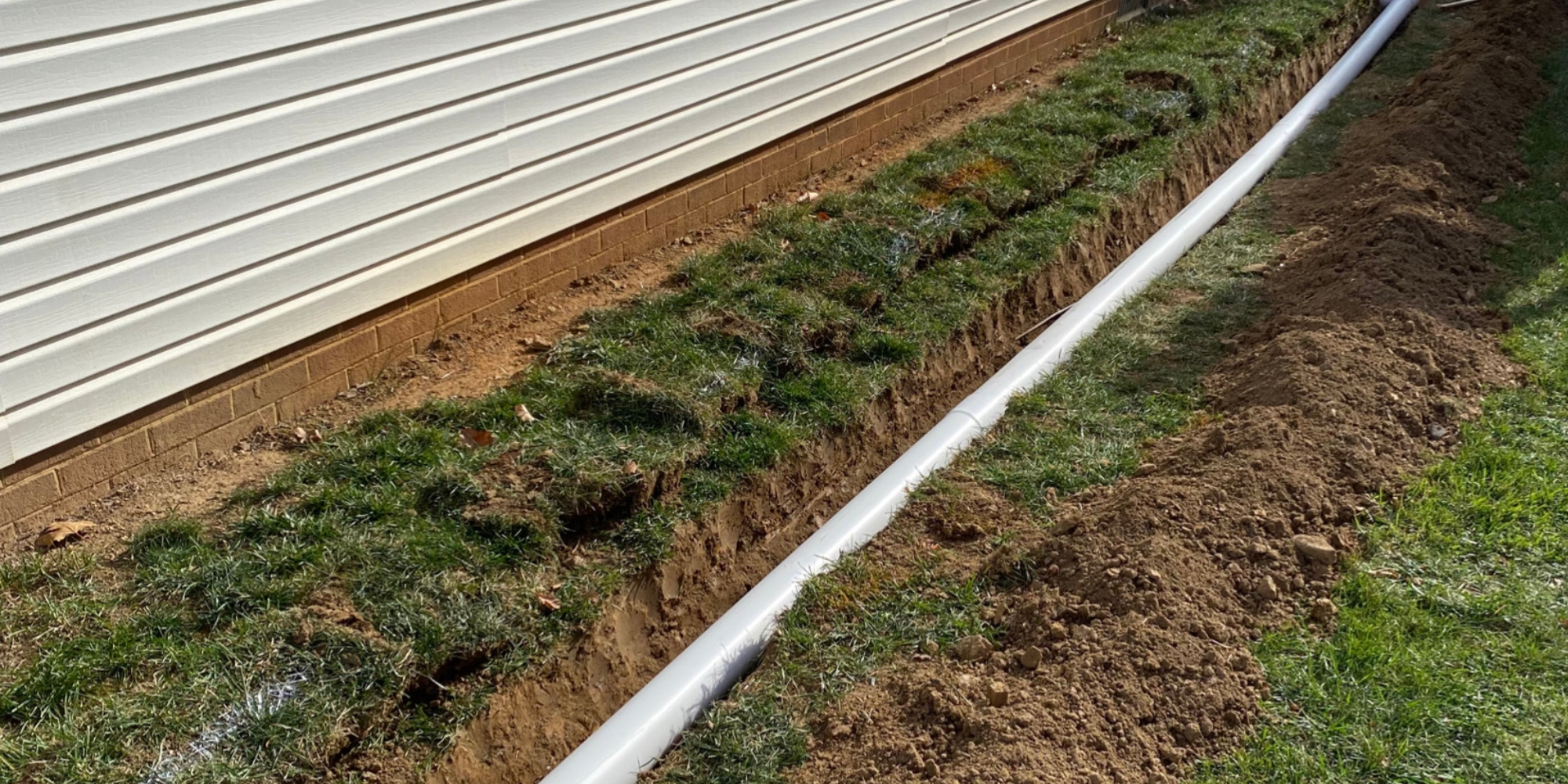 Installed French drain trench in a residential yard to redirect water away from the foundation in Northern Virginia