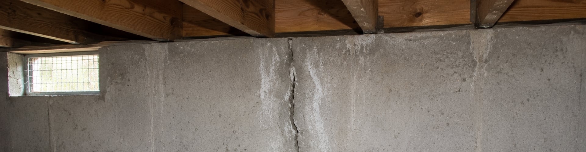 Vertical crack running through a concrete crawl space foundation wall inside a Northern Virginia residential home.
