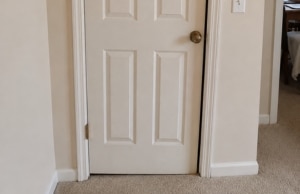 Door sitting unevenly in its frame due to foundation shifting, a sign of foundation settlement problem in Ashburn, VA.