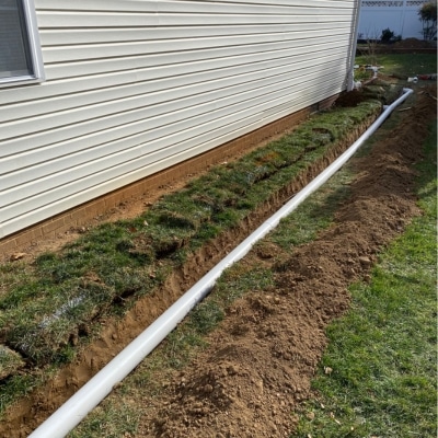 French drain installation along a home foundation to redirect water and prevent settlement in Flint Hill, VA.