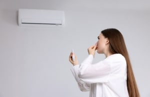 Woman covering nose from musty odor coming through HVAC from high humidity crawl space in Clear Brook, VA.
